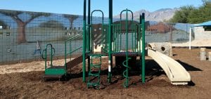 green playground with tan slide